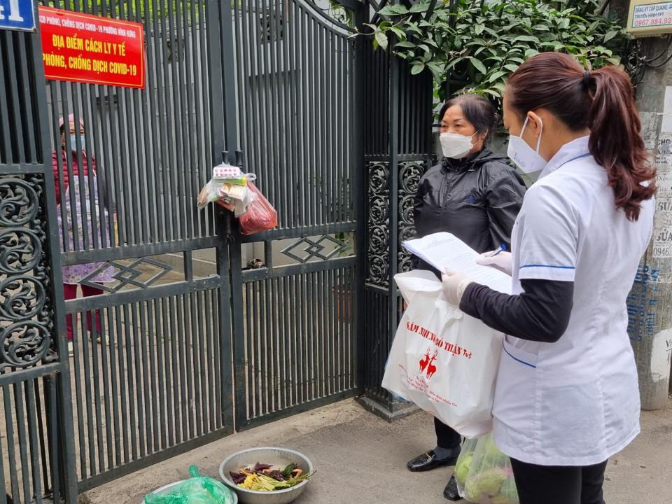 Phát thuốc và hỗ trợ thực phẩm cho gia đình có trường hợp F0 tại phường Vĩnh Hưng.