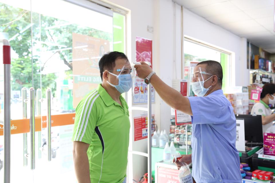 Người dân đo thân nhiệt trước khi vào siêu thị BRG Hapro Thành Công. Ảnh: Thanh Hải  