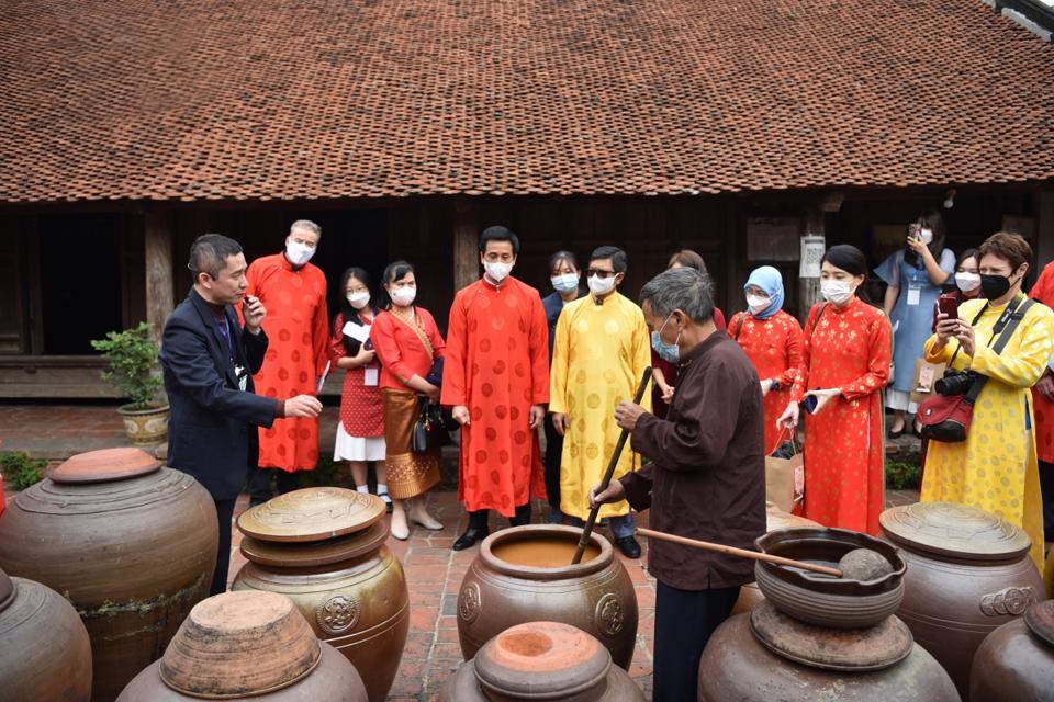 Khách du lịch quốc tế tìm hiểu nghề làm tương tại Đường Lâm, Sơn Tây, Hà Nội. Ảnh: Nam Hải