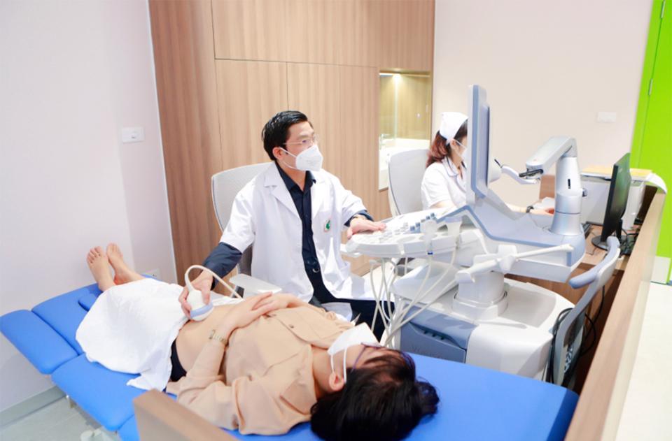 PGS.TS Nguyễn Duy Ánh - Giám đốc Bệnh viện Phụ sản Hà Nội siêu âm, thăm khám cho sản phụ.