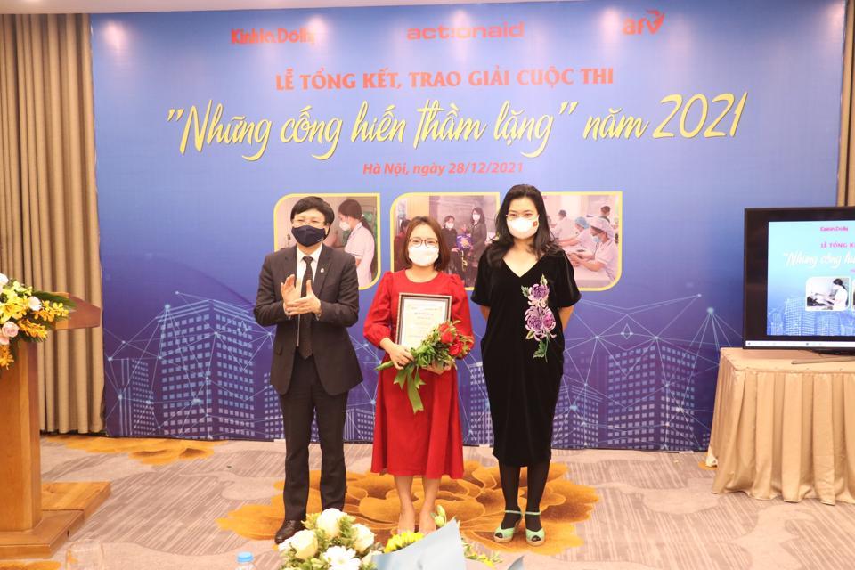 Tác giả Khắc Nam (Nhà báo Trần Thị Nam Trang, đứng giữa) đến từ báo Tuổi trẻ Thủ đô được Ban Tổ chức trao giải Nhất cuộc thi “Những cống hiến thầm lặng” năm 2021 với loạt 3 bài Tạo môi trường an toàn, văn minh để lao động nữ yên tâm cống hiến.