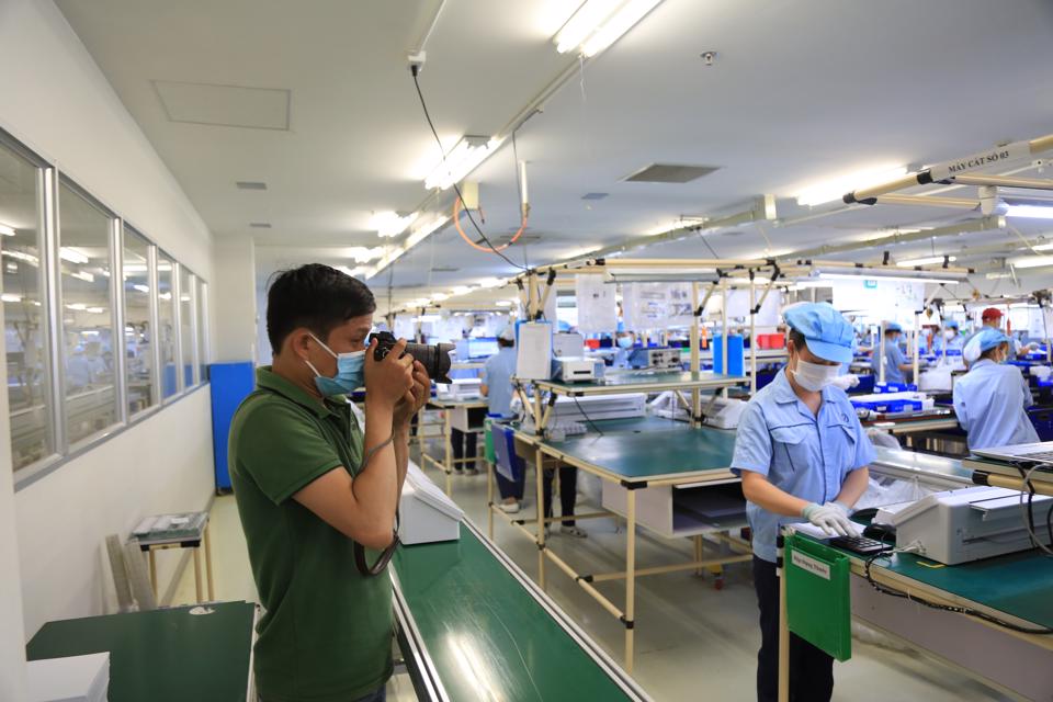 Phóng viên báo Kinh tế & Đô thị tác nghiệp phản ánh hoạt động phục hồi sản xuất tại Khu công nghiệp Nội Bài, Hà Nội. Ảnh: Công Hùng