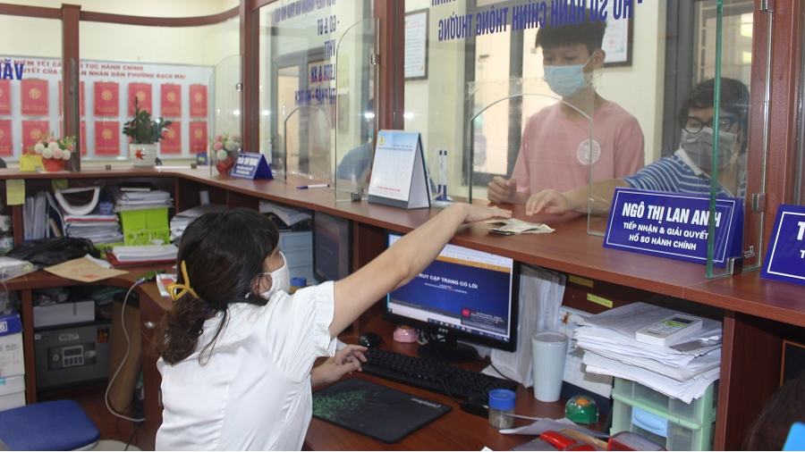 Công chức bộ phận một cửa UBND phường Bạch Mai, quận Hai Bà Trưng hướng dẫn, tiếp nhận giải quyết TTHC cho người dân. Ảnh: Thùy Linh  