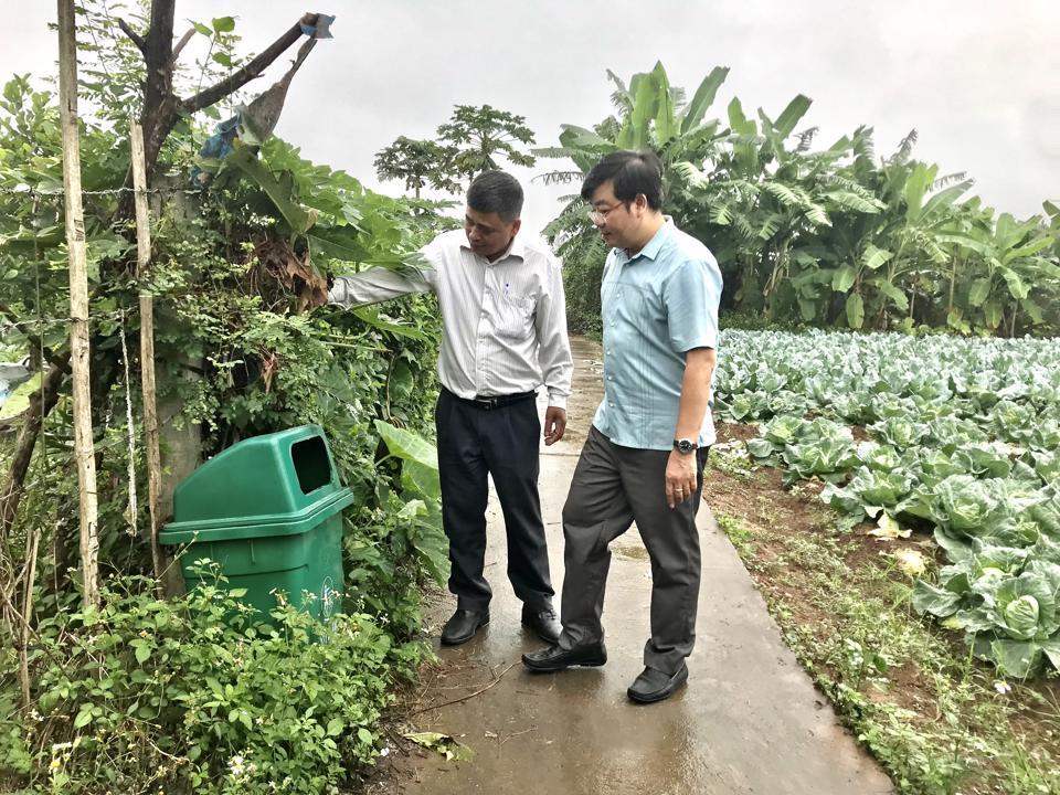 Chủ tịch Hội Nông dân huyện Thanh Trì Nguyễn Sỹ Thành (phải) và Chủ tịch Hội Nông dân xã Yên Mỹ Trần Quyết Thắng giới thiệu mô hìnhxử lý vỏ bao bì thuốc bảo vệ thực vật tại ruộng.