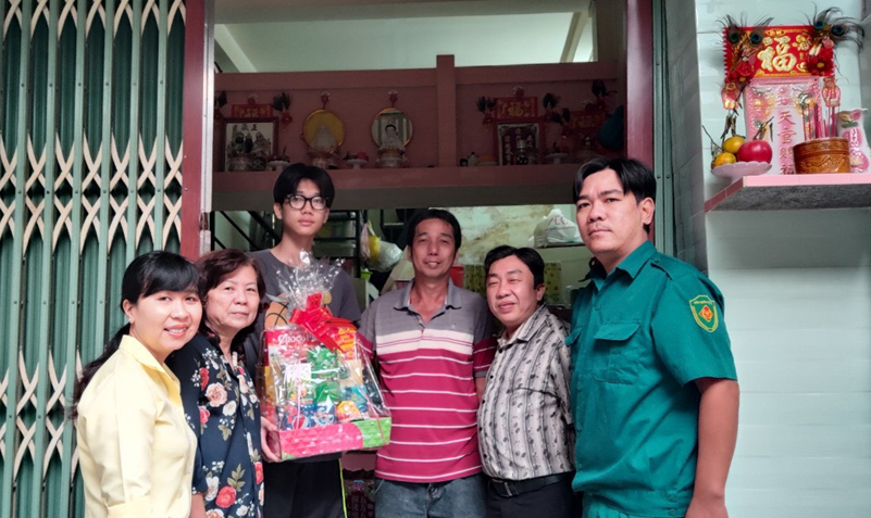 Cán bộ UBND phường 1, quận 6 thăm hỏi, tặng quà cho gia đình em Trần Bảo Quang (thứ 3 từ trái sang).