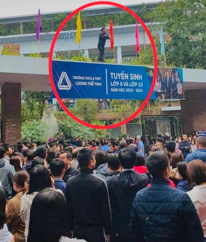 Hình ảnh thầy giáo trèo lên cổng trường điều tiết giao thông, trật tự tại Trường THCS và THPT Lương Thế Vinh (Ảnh: FB Người đồng hành)