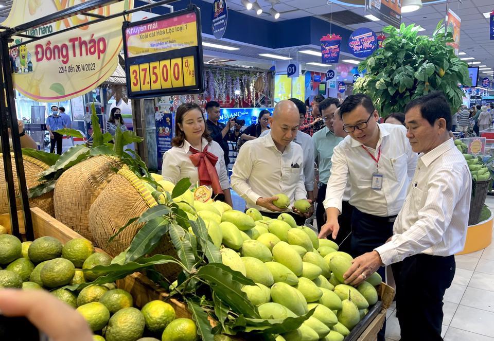 Ông Nguyễn Hữu Dũng (bìa phải), Giám đốc Sở Công thương tỉnh Đồng Tháp đang giới thiệu về xoài tại siêu thị. Ảnh PV