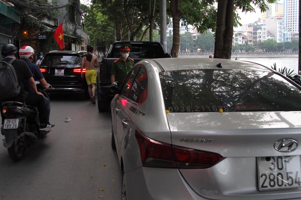 Lực lượng chức năng kiểm tra, xử lý trường hợp dừng đỗ phương tiện sai quy định gây cản trở giao thông quanh hồ Hoàng Cầu.