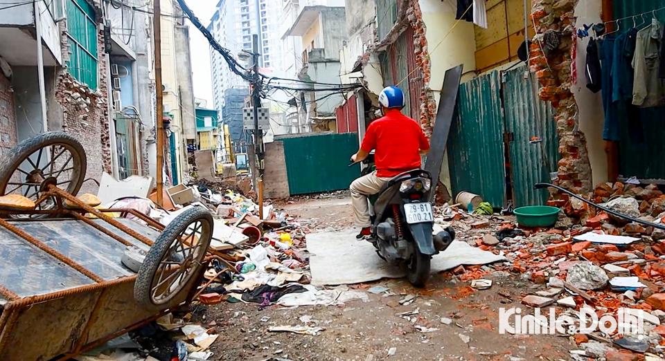 Vật liệu xây dựng, rác thải bừa bãi trên lòng đường khiến người dân sinh sống tại đây gặp nhiều khó khăn khi di chuyển.