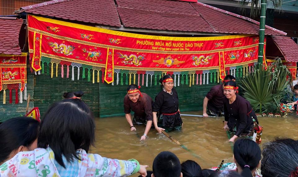 Khách du lịch xem múa rối nước tại sân khấu thủy đình Đào Thục. Ảnh: Kiên Hải