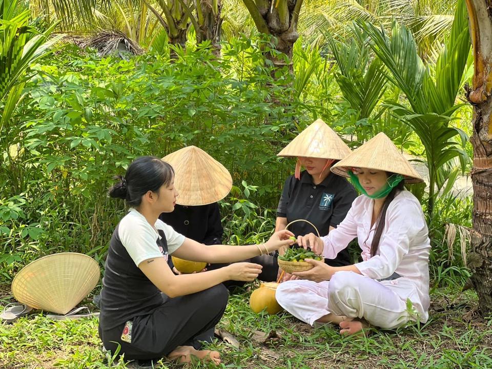 Du khách thích thú khi được thưởng thức nước dừa, trái cây tại vườn. Ảnh: Tạ Quang  