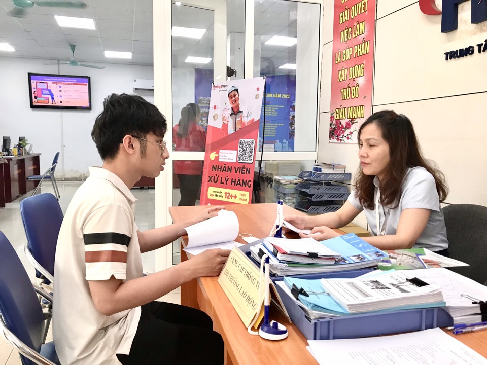 Cán bộ Trung tâm Dịch vụ việc làm Hà Nội đang giới thiệu các vị trí việc làm cho người lao động. Ảnh: Trần Oanh.  