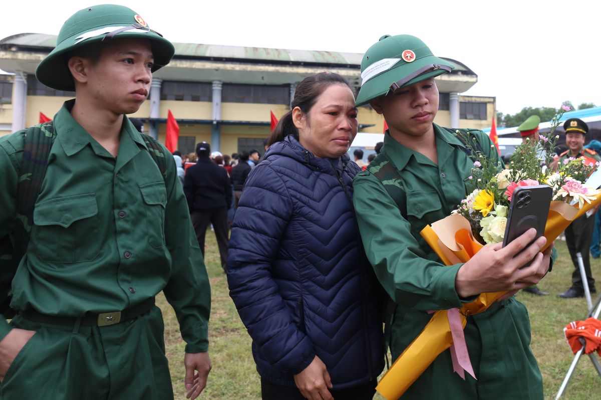 Đi vào quân ngũ trong tâm thế thoải mái, bố mẹ hết sức ủng hộ. Nhưng phút chia, tay, mẹ và hai con đều xúc động. Trong ảnh, Minh mượn điện thoại chụp chung với mẹ tấm hình trước khi lên xe về đơn vị.