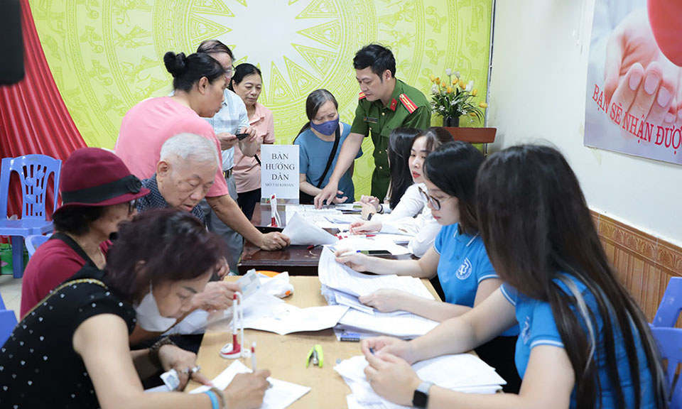 Cán bộ BHXH Hà Nội hướng dẫn người dân làm thủ tục nhận lương hưu, trợ cấp BHXH không dùng tiền mặt.