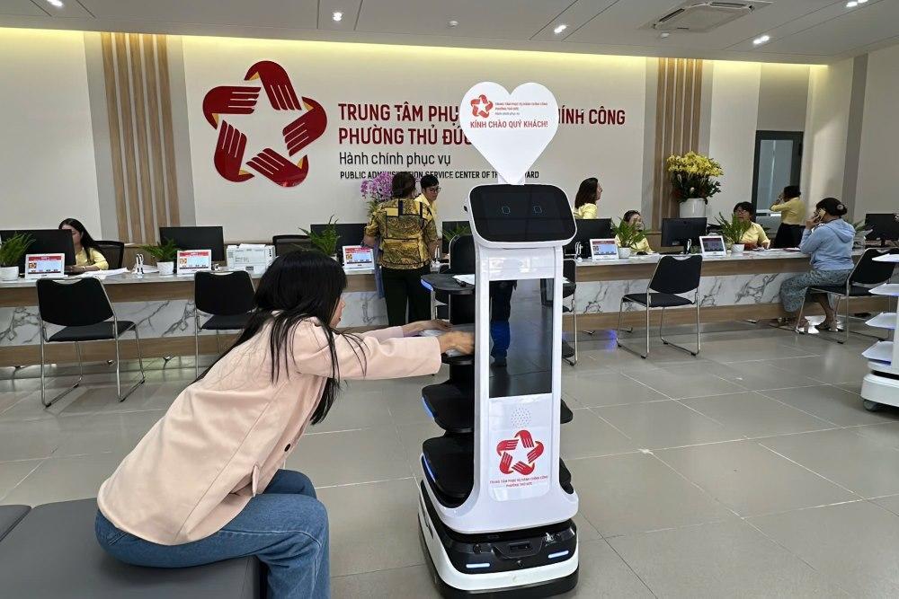 Người dân chỉ cần ngồi tại chỗ và đặt hồ sơ lên robot. Ảnh: Anh Tú