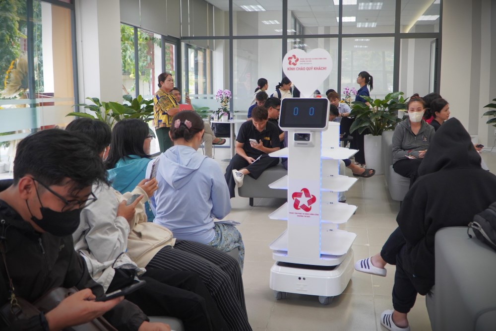 Robot di chuyển xung quanh khu vực chờ để tiếp nhận hồ sơ. Ảnh: Anh Tú