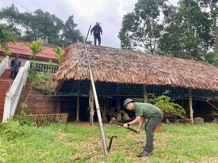 Lực lượng công an các xã giúp dân gia cố mái nhà trước khi bão số 3 đổ bộ vào đất liền. Ảnh Đức Mạnh