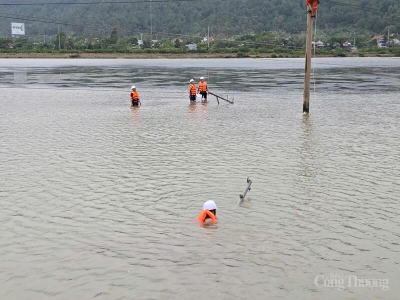 Công nhân Công ty Điện lực Thanh Hóa  bơi trong dòng nước để vận chuyển thiết bị sửa chữa khắc phục sự cố lưới điện tại khu vực Nghi Sơn