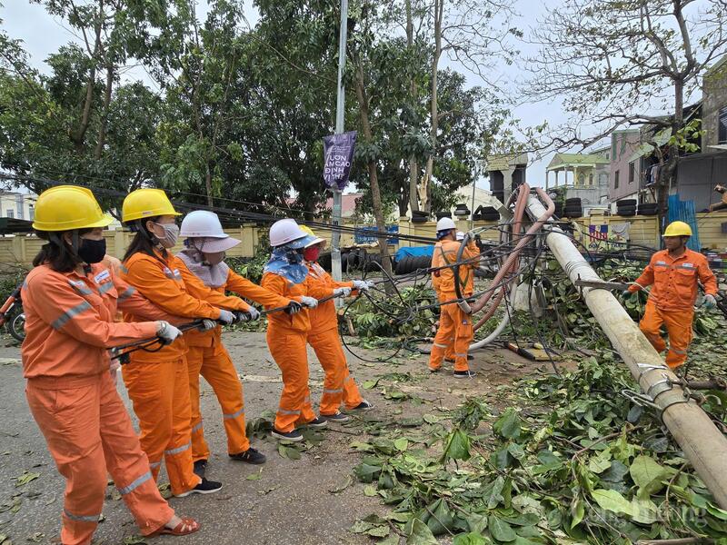 Công nhân Công ty Điện lực Nghệ An đang xử lý cột điện gãy đổ sau bão số 5