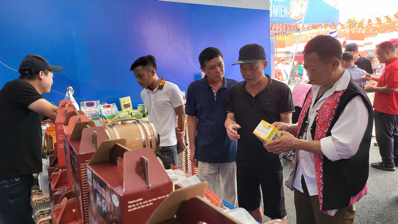 Anh Nguyễn Tiến Mạnh, Giám đốc Hợp tác xã Nông sản Dược liệu Mạnh Hương (ngoài cùng bên phải) đang giới thiệu sản phẩm với người tiêu dùng. Ảnh: Ngọc Tiến