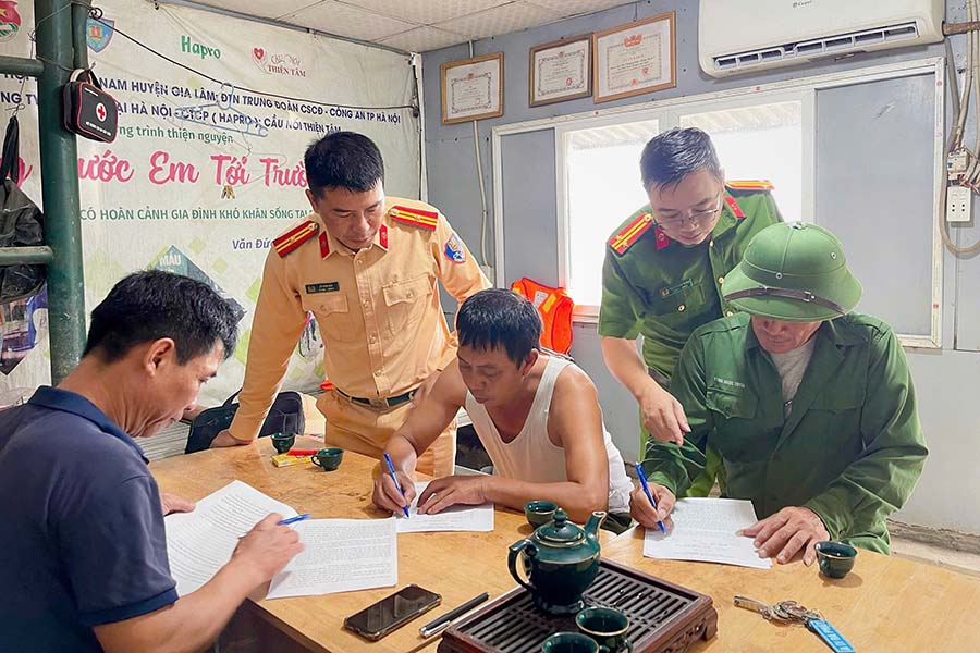 Lực lượng chức năng yêu cầu chủ bến ký cam kết không cho phà xuất bến khi thời tiết xấu. Ảnh: Tiến Ngô