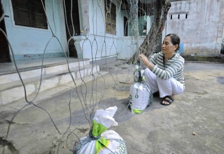 Người dân dùng bao cát để chằng chống nhà cửa ứng phó bão.